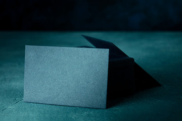 Business cards, a blank mock-up for a stack of dark blue thick cardboard cards on a dark backgroud...