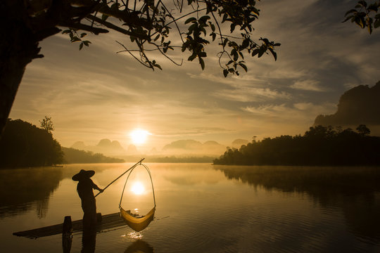 Fisherman is fishing at Baan Nong Thale in Krabi, Thailand during sunrise.