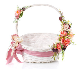 Fototapeta na wymiar Original wicker basket with a beautiful, delicate pink decor with a pink ribbon around the basket. On a white background.