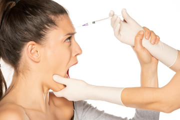 Portrait of a young scared woman on a faace filler injection procedure