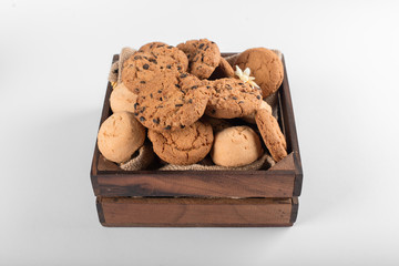 Wooden rustic tray of mixed cookies isolated on white