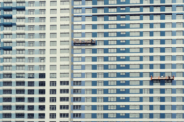 Builders perform facing work on the facade of the house