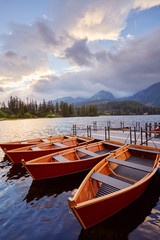 Berth with boats on a mountain lake in the rays of the sunset.