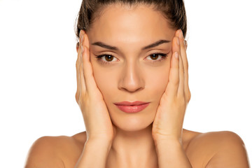 a young beautiful woman tightens her face with her hands