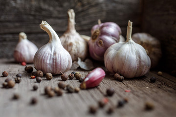 Garlic banner. Garlic bulbs on wooden rustic background. A bunch of spices on the side.