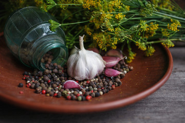 Ingredients for preservation. Garlic, garlic cloves, spices and dill lie on a flat wooden plate.