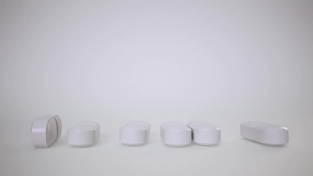 A stack of medicines falls over on white background