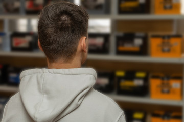 Rear view of a man in a car battery and parts store