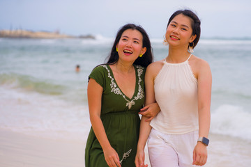 young beautiful and happy couple of attractive Asian Chinese women walking together relaxed at the...