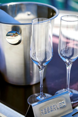 Romantic luxury evening on cruise yacht with champagne setting. Empty glasses and bottle with champagne and tropical sunset with sea background