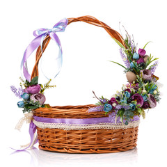 Fototapeta na wymiar Floral composition with flowers, greenery and ribbons hanging on the handle of a wicker basket on white background