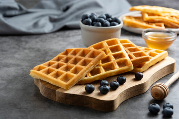 Belgian waffles with blueberry and honey for breakfast. Delicious homemade pastry.