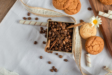 Coffee beans and cookies on a blue tablecloth. top view