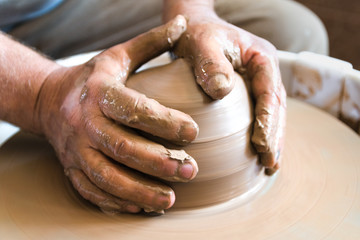 Craftsman at work. Working process of loam item in workshop. Man working in home studio.