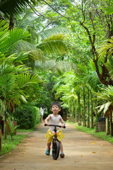 happy cute boy playing balance bike in the park have fun, family outdoor activity of healthy