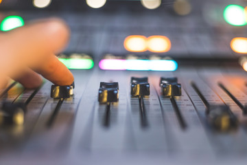 Sound recording studio mixer desk: sound engineer is operating a professional music production