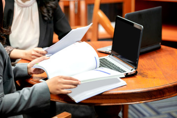 Businesswoman with laptop and document discussing business