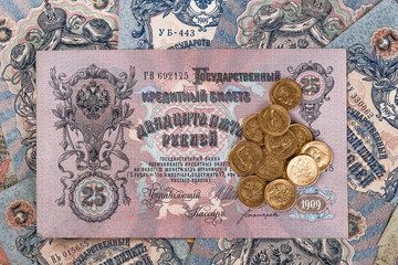 Fototapeta na wymiar Gold and silver coins of the Russian Empire19 - 20 century in the background kopyur.Five rubles Nicholas II.Concept Russian antiques.Antikvariat.