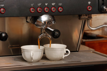 Closeup of espresso machine making cappucino cup of coffee
