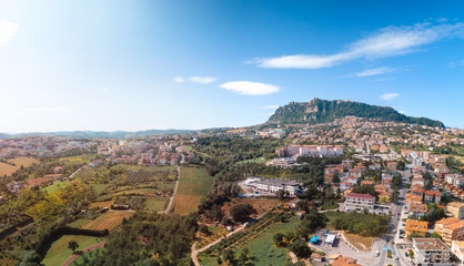 Fototapeta na wymiar Aerial landscape view from distance on main city rock of San Marino Republic in the background. The concept of the best places for tourism and journey. Down town, Italy
