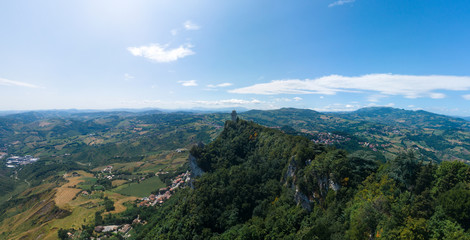 Fototapeta na wymiar Aerial view on Third, distant tower on top of the mountain. Fortifications, in the background mountains and the city. The concept of wide panorama wallpaper Europe. San Marino, Italy