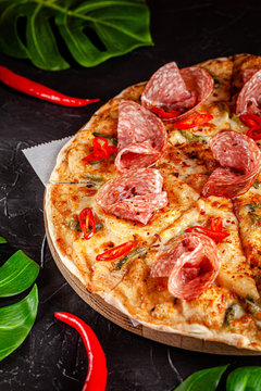 Neapolitan, Mexican cuisine. Pizza with salami sausage, with red pepper, jalapenos, pickled cucumbers and tomato pilati sauce. background image, copy space text