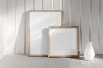 Two portrait and square wooden frame mockups. Linen cloth and modern ceramic vase with in sunlight....