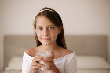 Portrait of cute girl drinking milk at home