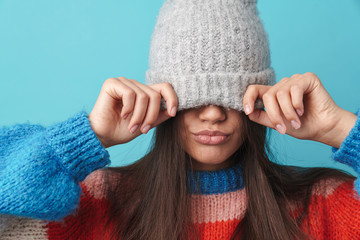 Woman posing isolated covering face with hat.