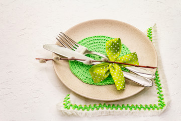 Easter table setting on textured white putty background. Spring holiday card template. Cutlery,...