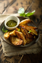 Roasted potato wedges with homemade pesto sauce