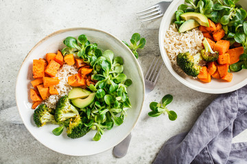 Vegan lunch bowl with rice, broccoli, sweet potato, rice and salad, top view, copy space. Vegan...