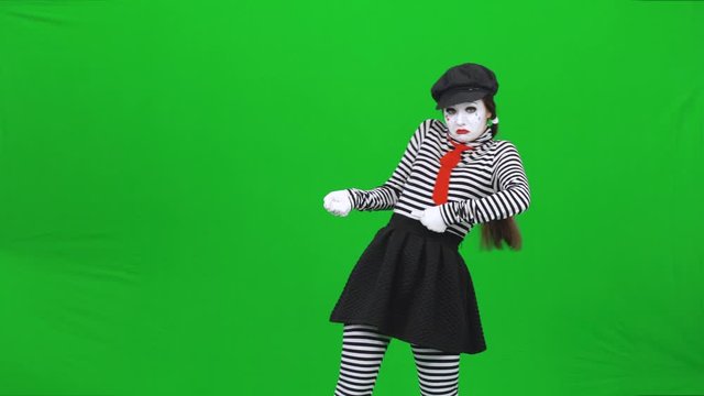 Mime girl is hardly pulling a rope, smiling. Chroma key.