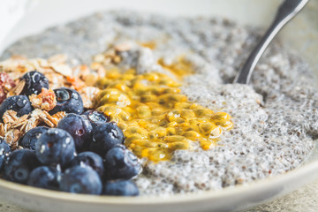 Chia pudding bowl with blueberries, passion fruit and granola. Healthy breakfast concept.