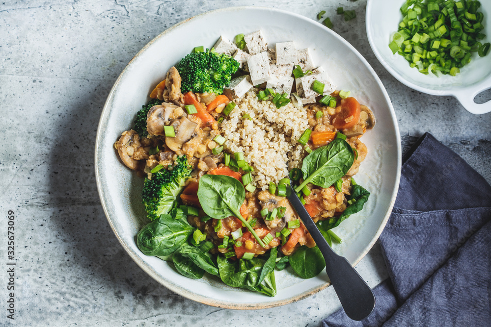 Poster Lentil vegan stew with mushrooms, quinoa, spinach and broccoli in a bowl, top view. Healthy vegan food concept.