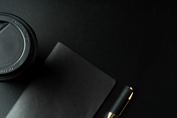 Black notepad with pen on black table close up