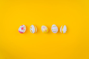 Colorful easter painted eggs background on yellow pastel color background with space. Easter holiday concept. Traditional decoration for springtime holiday. Top view easter greeting card