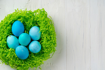 Fototapeta na wymiar Blue painted eggs in a nest for Easter