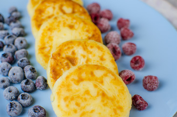Cheesecakes in a blue dish with frozen fruit. Homemade, delicious food