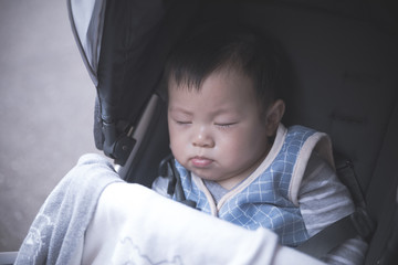 Asian little baby boy sleeping in stroller