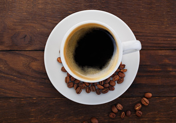 cup of coffee grains on a wooden background