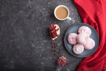 Pink pomegranate homemade zephyr or marshmallow with cup of coffee on a black concrete background. top view, copy space.