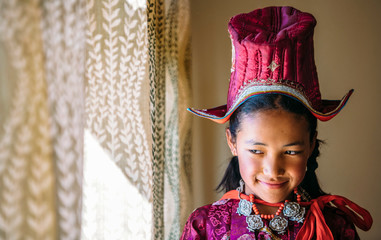 Portrait of a beautiful young girl in typical tibetan clothes with hat in Ladakh, Kashmir, India - 325677851