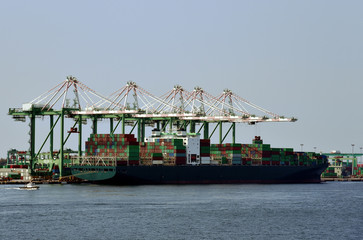 Cargo container ship in the sea port of Kaohsiung, Taiwan. Gantry cranes are loading cargo in the...