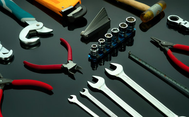 Set of mechanic tools on dark background. Chrome wrenches or spanners, hexagon socket, end cutter pliers, locking pliers, pincers, feeler gauge, bent wrench and hammer. Chrome vanadium spanner wrench. - obrazy, fototapety, plakaty