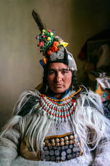 Portrait of a woman in typical tibetan clothes inside her house in Ladakh, Kashmir, India. - obrazy, fototapety, plakaty