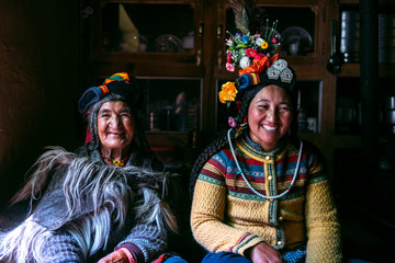 Portrait of women in typical tibetan clothes inside their house in Ladakh, Kashmir, India. - obrazy, fototapety, plakaty