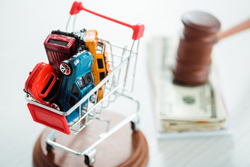 selective focus of shopping trolley with models of cars