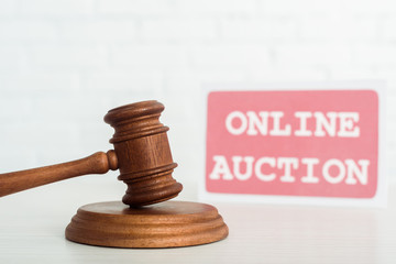 selective focus of gavel and card with online auction lettering on background