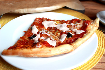 slice of pizza with cheese and olives on plate